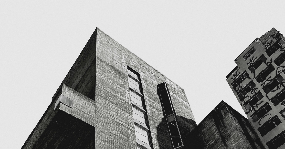 Dramatic black and white brutalist concrete structure with sharp angular geometry shot from below