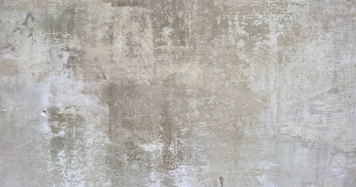 Abstract close-up of light and shadow falling across a textured concrete surface